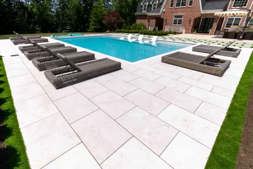Luxurious pool surround designed with Crema Winter Marble Pavers by Elegance, featured in New Jersey.