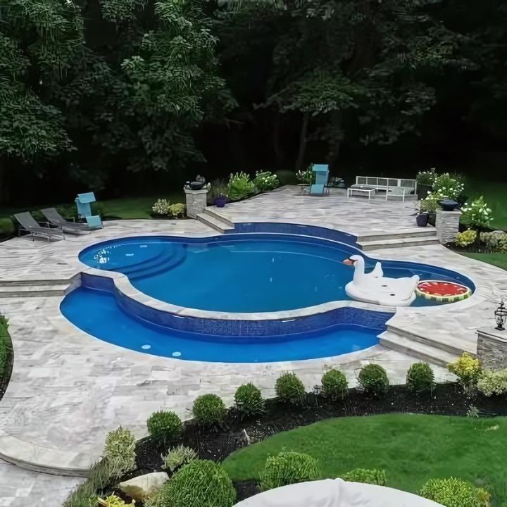 a beautiful travertine deck surrounds a swimming pool, showcasing an environmentally friendly and sustainable choice for outdoor decking material.