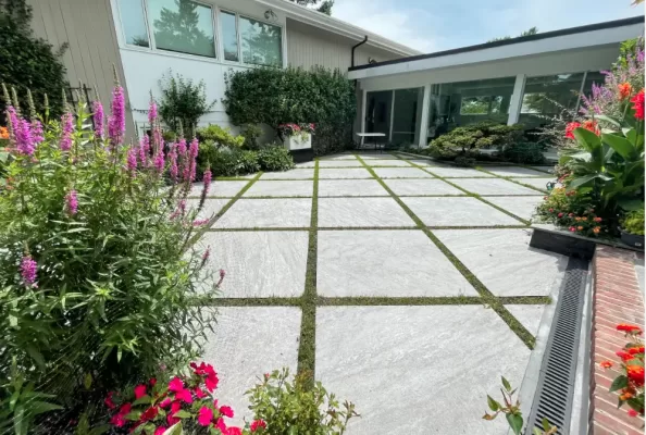 The image shows the outside of the house designed with mediterrenean porcelain paver patio.