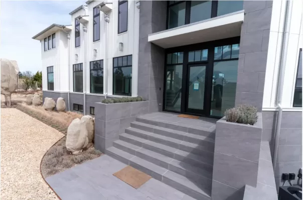 Image shows outsite of the building that designed with dark grey porcelain pavers.