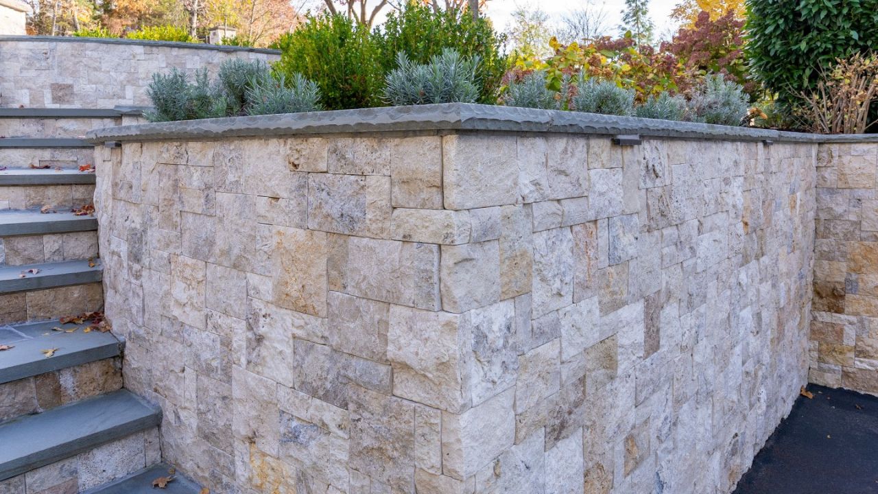 Natural stone retaining wall ideas with tiered landscaping and stone steps